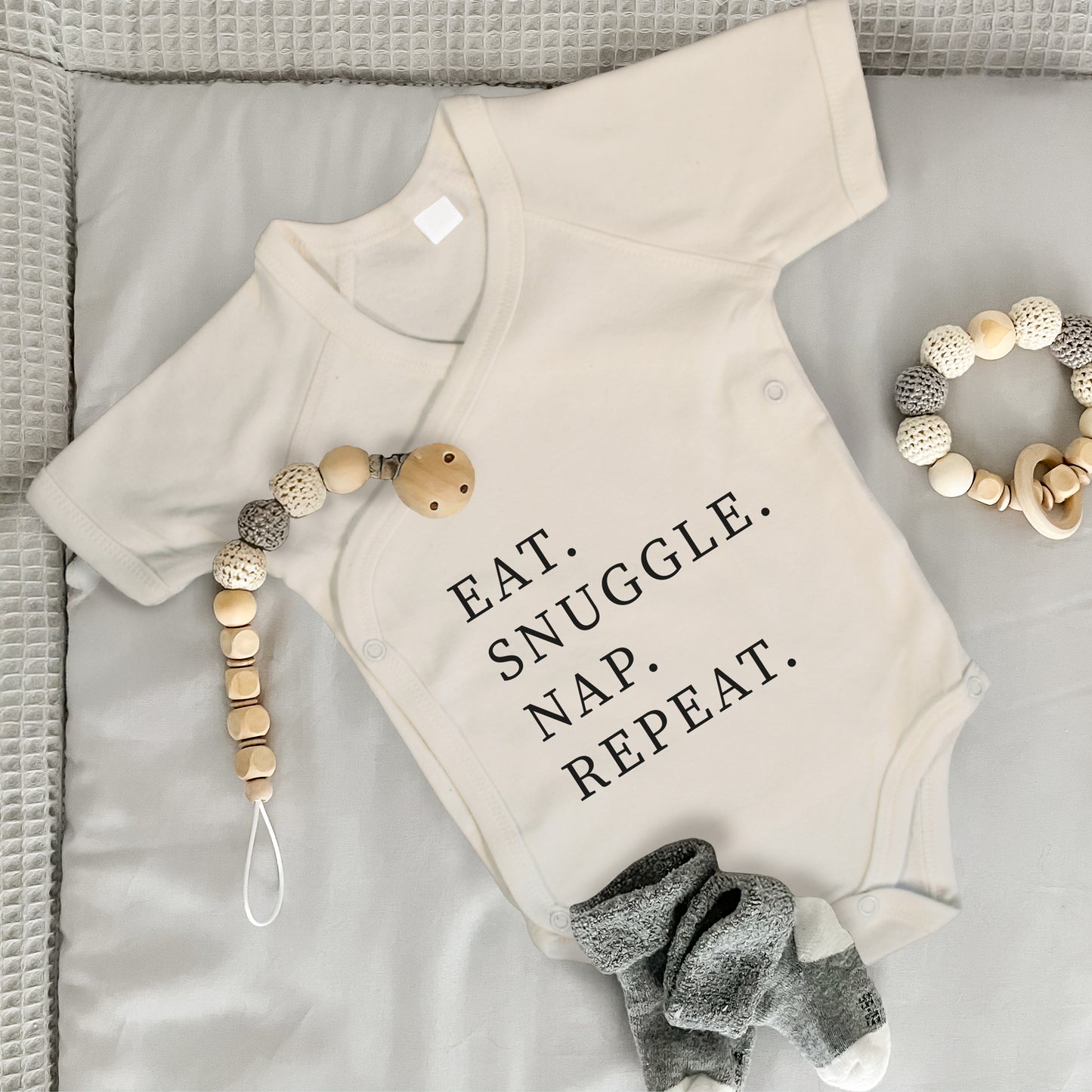 Baby Body Kurzarm mit Spruch | Wickelbody aus Bio-Baumwolle | Eat. Snuggle. Nap. Repeat.
