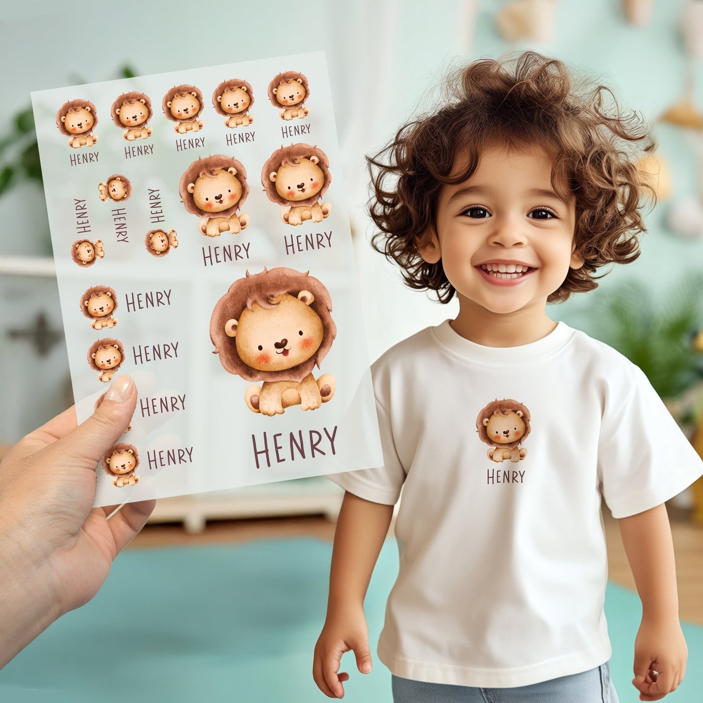 Kind trägt weißes T-Shirt mit aufgebügeltem Löwen-Motiv und personalisiertem Namen „Henry“, Bügelbild-Bogen wird im Vordergrund gezeigt