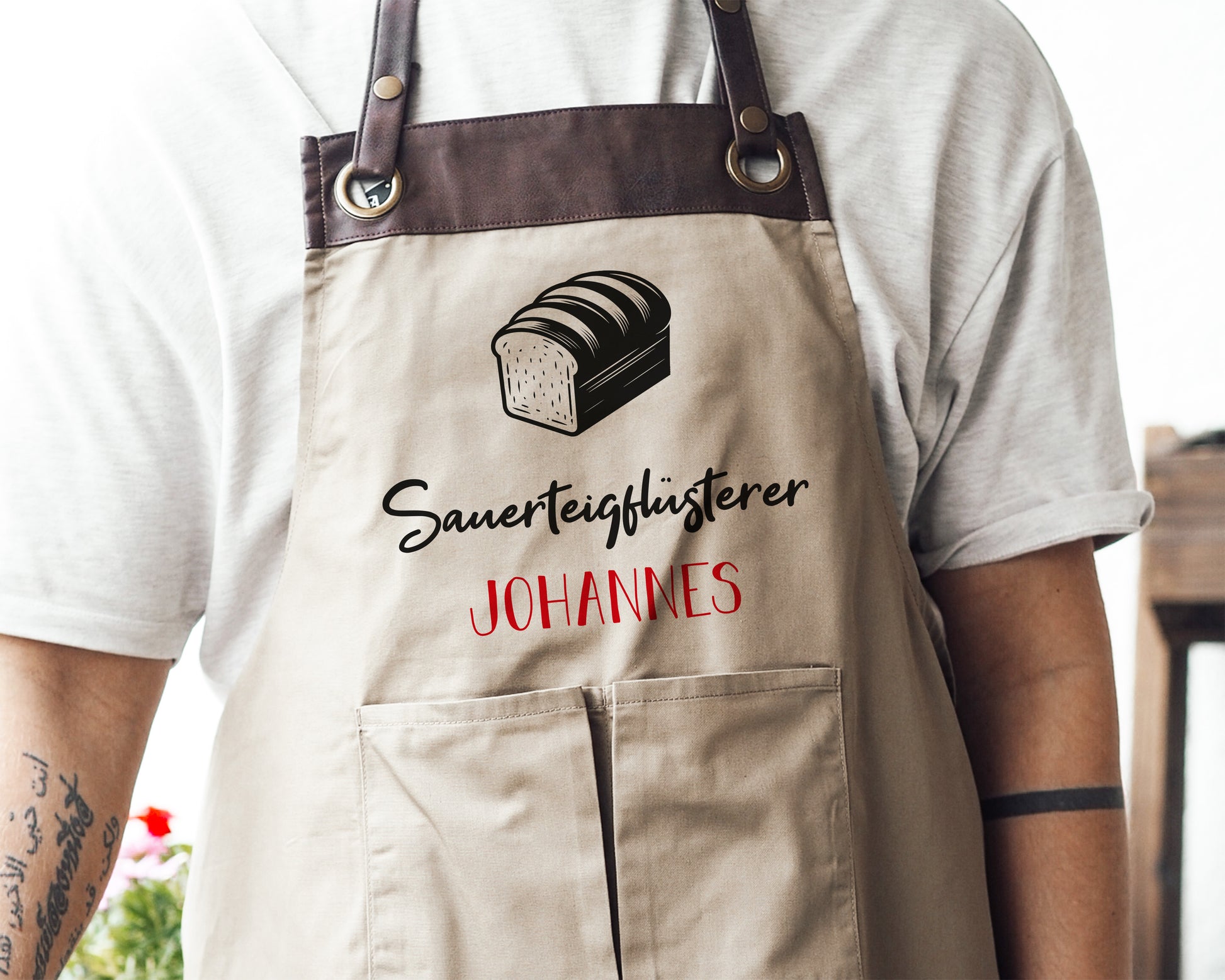 Personalisierte Backschürze mit Kunstleder Applikation „Sauerteigflüsterer“ in Beige oder Schwarz - verschenkich.de