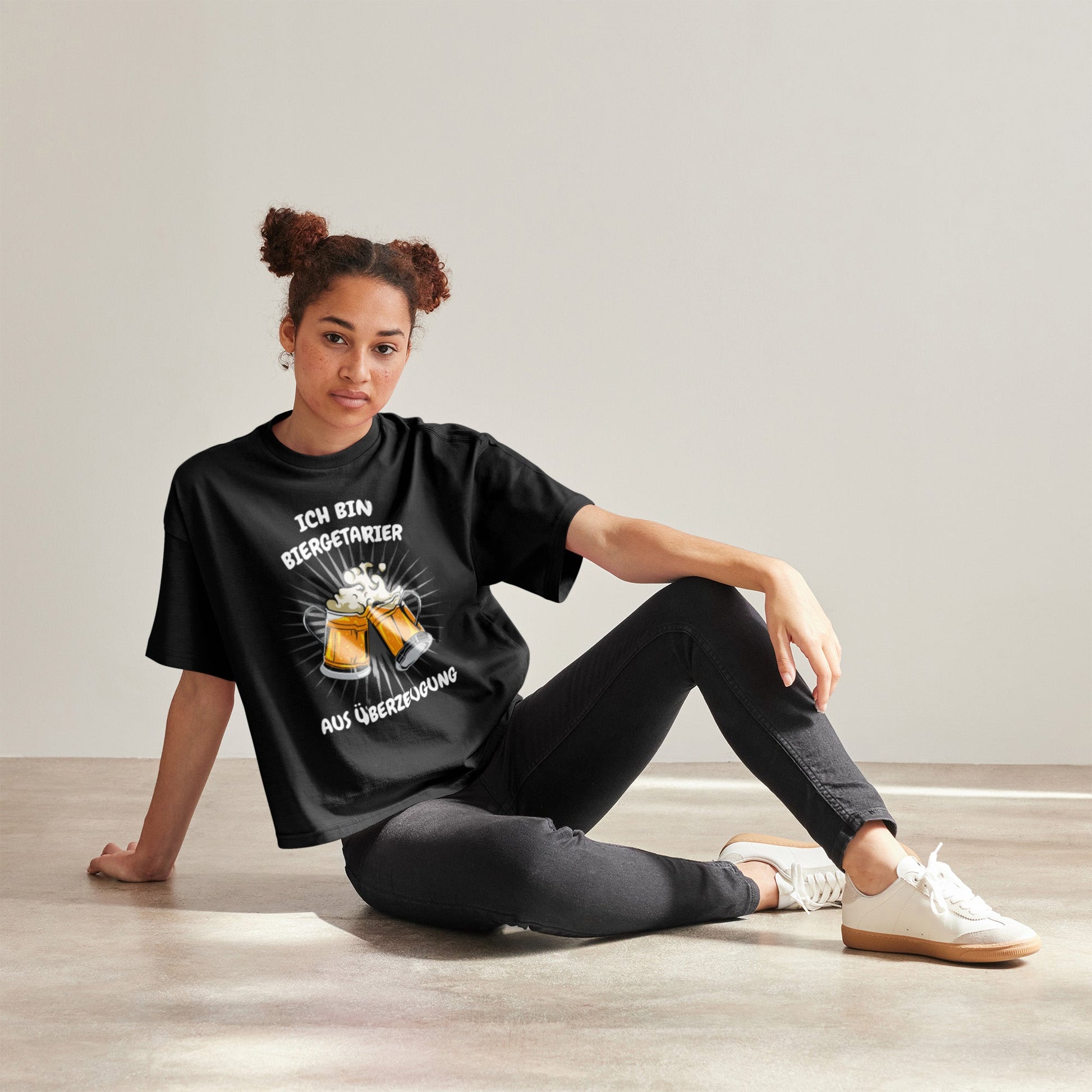 Frau trägt schwarzes Unisex T-Shirt mit dem Motiv „Ich bin Biergetarier aus Überzeugung“ und zwei Bierkrügen. Das Shirt besteht aus 100 % Bio-Baumwolle.