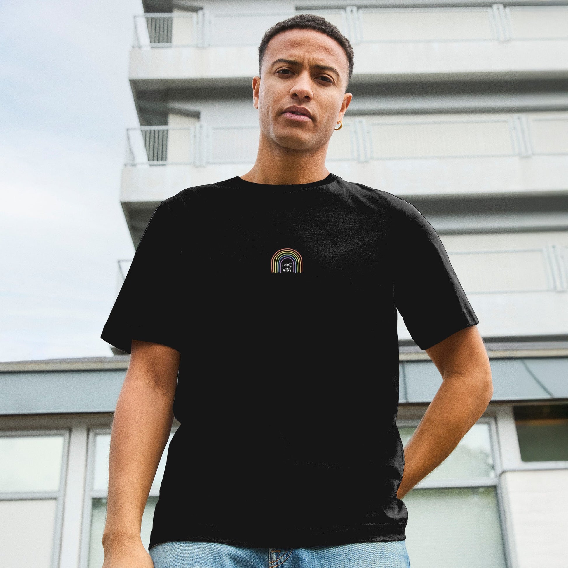Modell trägt schwarzes T-Shirt mit Love wins- Motiv - als Symbol für Stolz, Akzeptanz und die LGBTQIA+ Community.