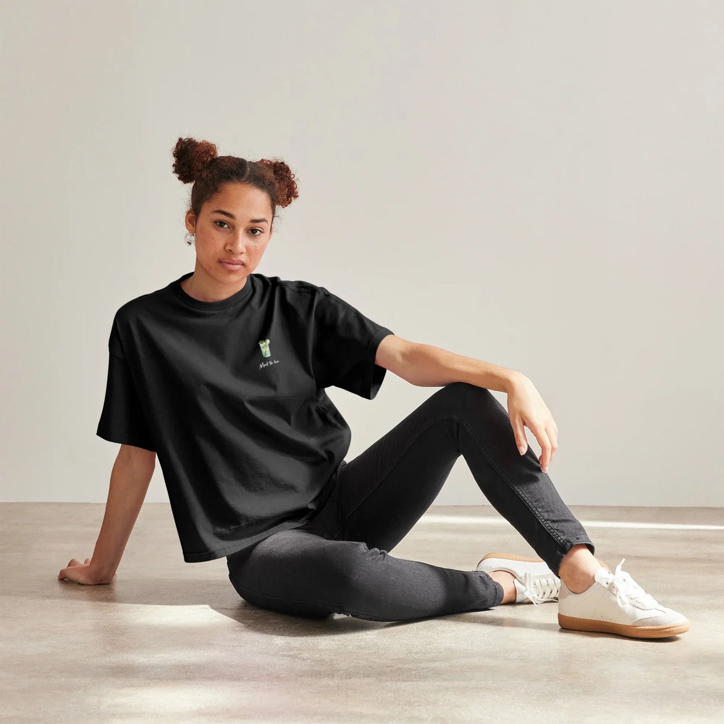 Frau trägt schwarzes T-Shirt mit dem Motiv eines Mojito-Glases, sowie dem Spruch „Mint to be“ auf der linken Brustseite.