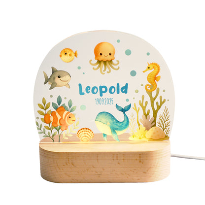 Beleuchtetes Nachtlicht mit Acrylplatte und Holzsockel aus Buche auf weißem Hintergrund, Unterwassermotiv mit Tieren wie Wal, Clownsfisch, Seepferdchen, Qualle und Kugelfisch.