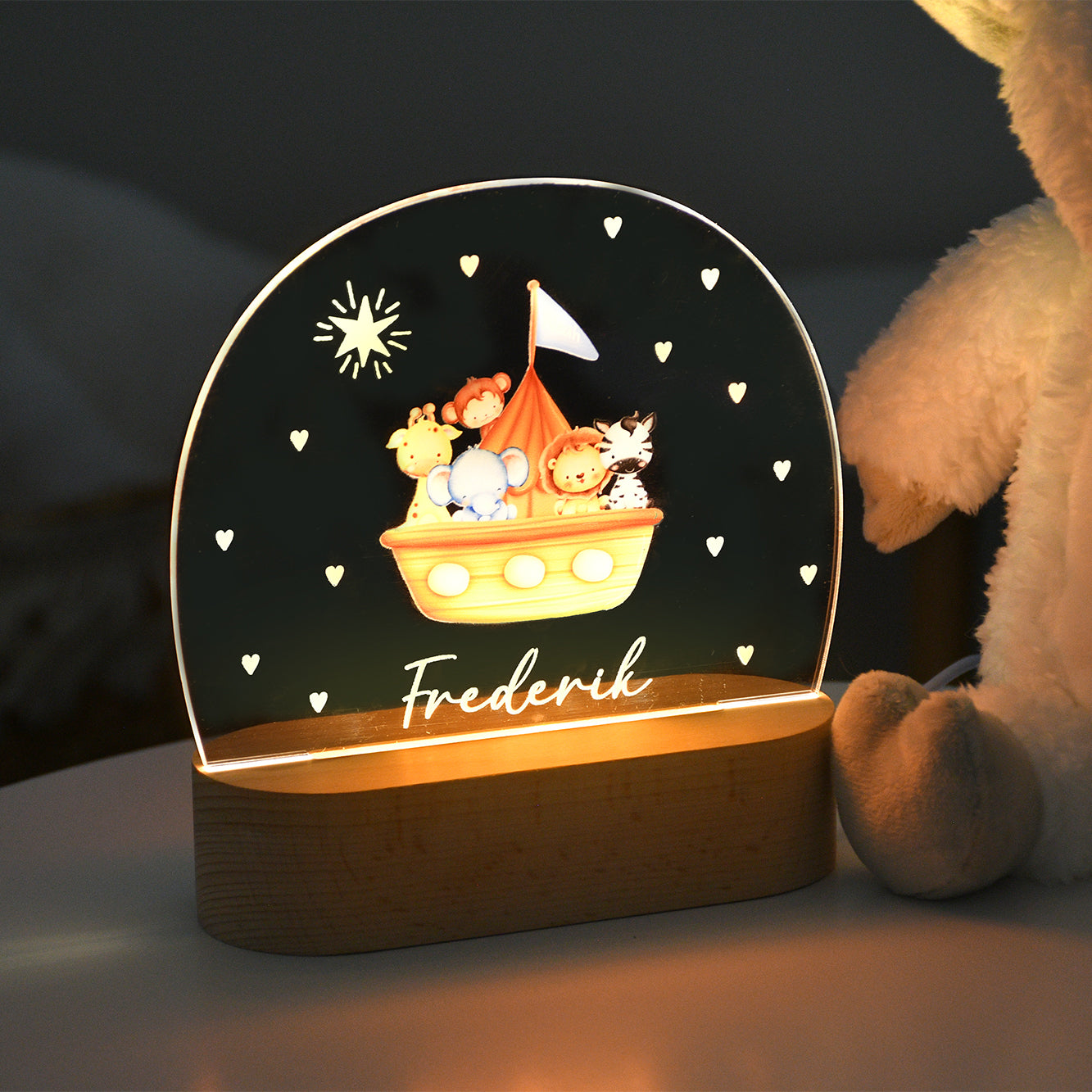 Beleuchtetes Nachtlicht mit Acrylplatte, Arche-Noah-Motiv mit Tierfiguren und dem personalisierten Namen „Frederik“, aufgenommen in dunkler Umgebung.