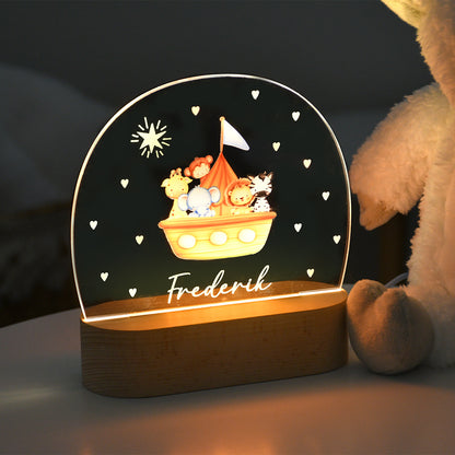 Beleuchtetes Nachtlicht mit Acrylplatte, Arche-Noah-Motiv mit Tierfiguren und dem personalisierten Namen „Frederik“, aufgenommen in dunkler Umgebung.