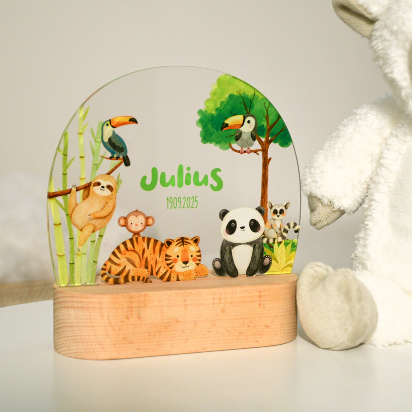 Unbeleuchtetes Nachtlicht mit Acrylplatte und Holzsockel aus Buche im Kinderzimmer, Dschungelmotiv mit Tieren wie Panda, Tiger, Tukan, Faultier und Affe, fotografiert bei heller Umgebung.