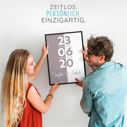 Zwei Personen halten personalisiertes Poster mit Datum und Namen, modernes Geschenkmotiv.