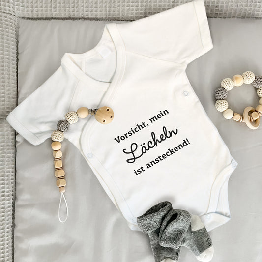 Baby Body Kurzarm mit Spruch | Wickelbody aus Bio-Baumwolle | Vorsicht, mein Lächeln ist ansteckend