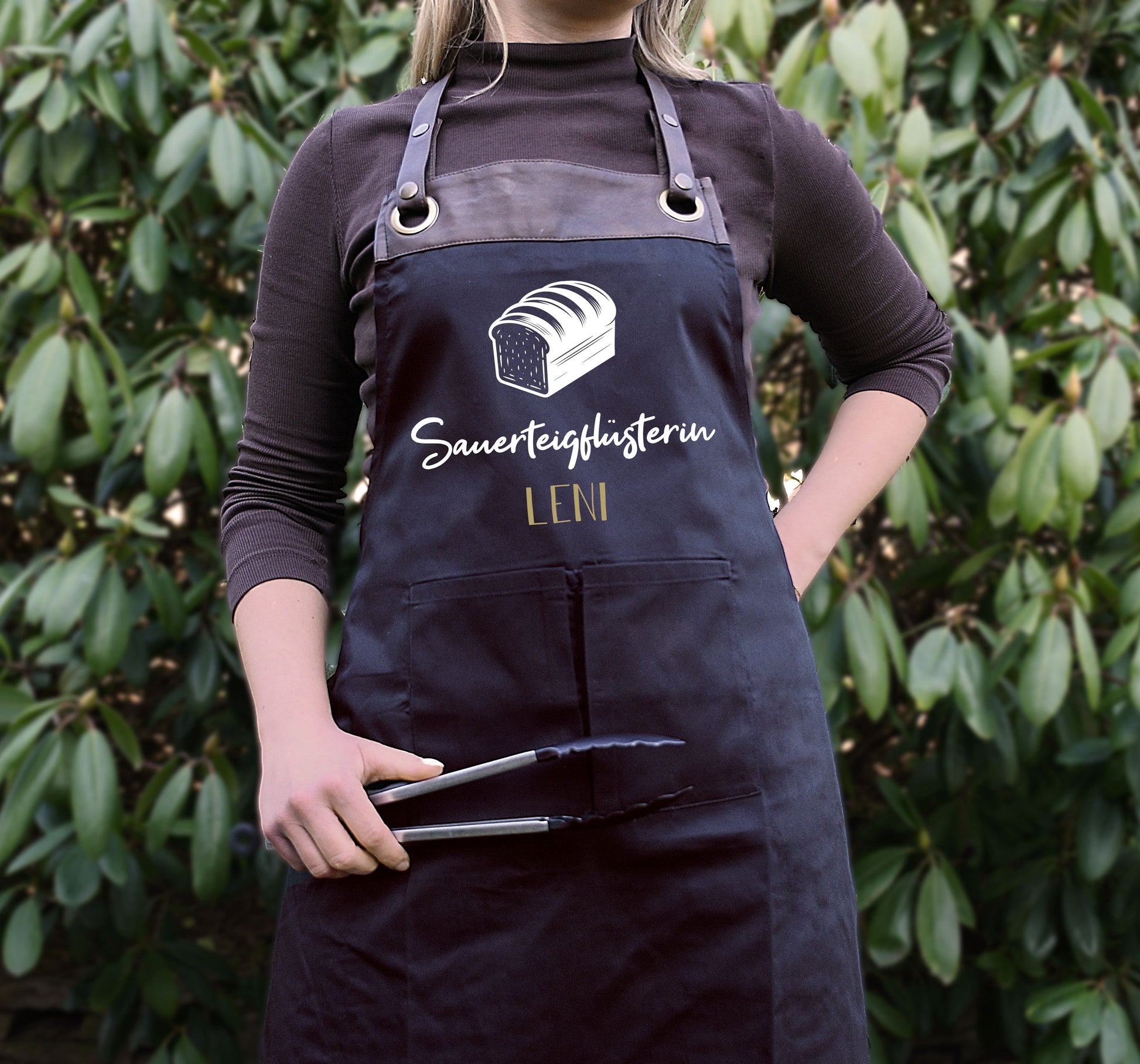 Personalisierte Backschürze mit Kunstleder Applikation „Sauerteigflüsterin“ in Beige oder Schwarz - verschenkich.de