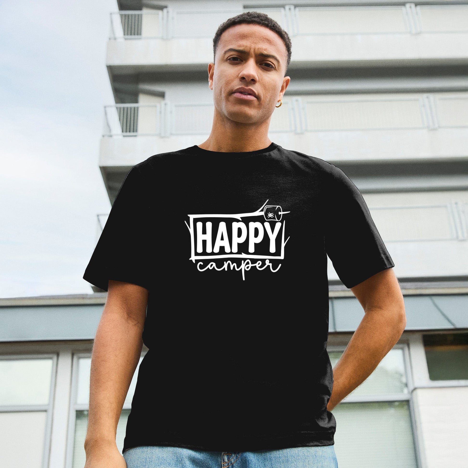 Modell trägt schwarzes T-Shirt mit Happy Camper Aufschrift eingerahmt in Ästen